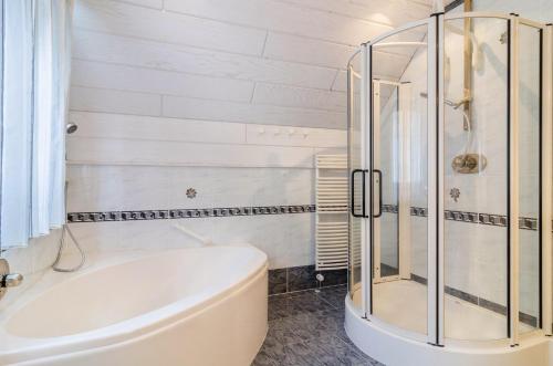 a bathroom with a tub and a glass shower at Schwarzwalduhren Nescht Triberg in Triberg