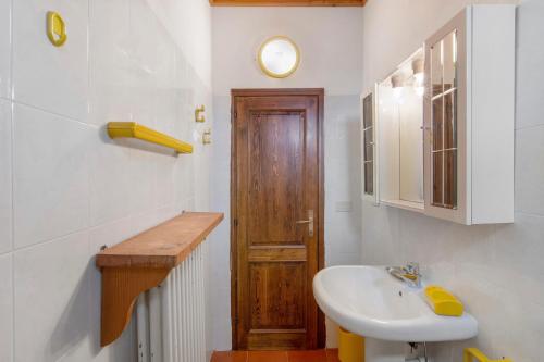a bathroom with a sink and a wooden door at La Baita Verde in Motta