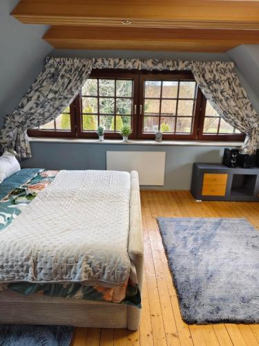 a bedroom with a bed and two windows at Ferienhaus Wurzinger in Mureck