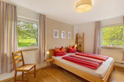 a bedroom with a large bed with red pillows at Ferienwohnung Peitz in Eslohe