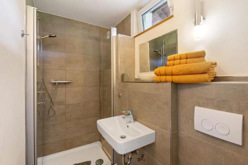 a bathroom with a sink and a shower and towels at Ferienwohnung Peitz in Eslohe