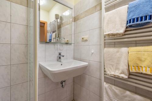 a bathroom with a sink and a mirror and towels at Pension Ufert in Meißen