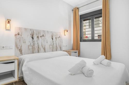 a hotel room with two beds and a window at Apartamentos Bellamar in Barbate