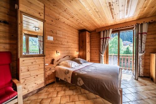 a bedroom with a bed in a wooden cabin at La Flèche d'Or in Châtel