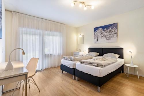 a bedroom with two beds and a desk at Zum Holzknecht in Willingen