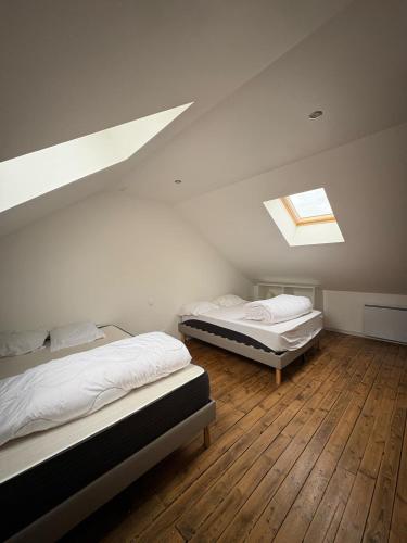 two beds in a attic room with a skylight at Maison de vacances avec piscine in Messeix