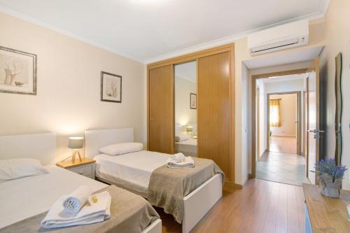 a hotel room with two beds and a bathroom at O'pomar 150 in Tavira