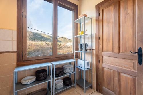 a kitchen with a window and a shelf with plates at La Posada in Chera