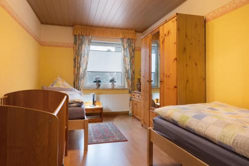 a bedroom with yellow walls and a bed and a window at Fewo Kaiser in Südbrookmerland