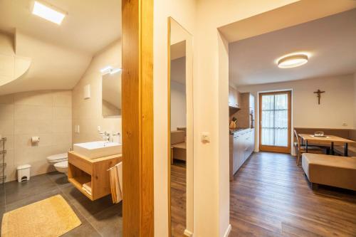 a bathroom with a sink and a toilet and a table at Parigger Apt Enzian in Racines