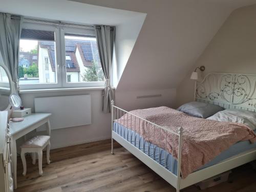 a bedroom with a bed and a desk and a window at Maisonette-Wohnung in Gladbeck in Gladbeck