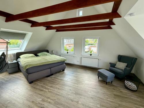 a bedroom with a bed and a chair at Ferienhaus Neeborg in Zetel