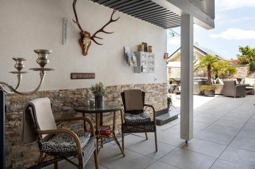 a patio with a table and chairs and a wall at Ferienwohnungen Eulenspiegel in Breisach am Rhein