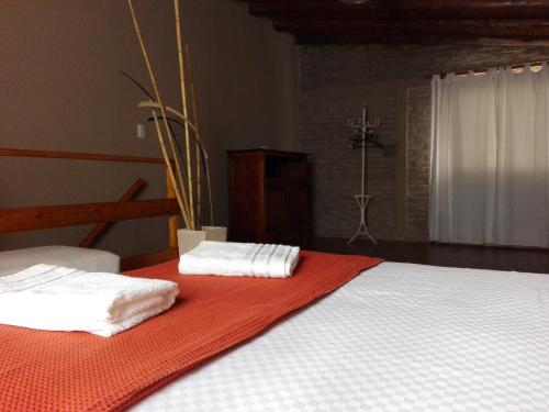 een bed met twee handdoeken op een rode deken bij Villa Carlos Paz Alojamiento Santa Ponsa in Villa Carlos Paz