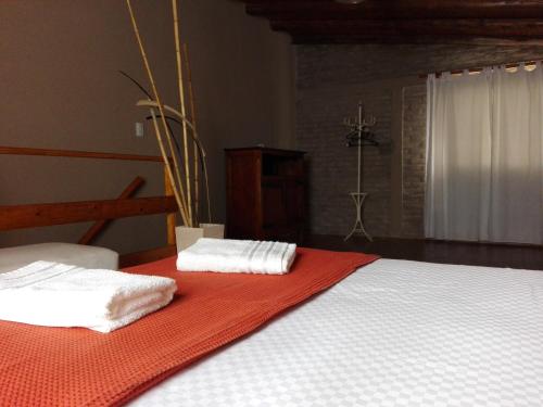 1 cama con 2 toallas en una manta roja en Villa Carlos Paz Alojamiento Santa Ponsa en Villa Carlos Paz