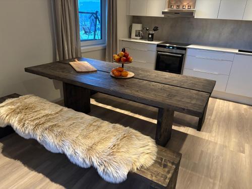 a wooden table with a bowl of fruit on it in a kitchen at Leilighet på RyenToppen med gapahuk in Kristiansand