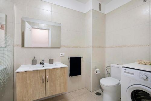 a bathroom with a sink and a toilet and a mirror at El Pisito de Momo in Candelaria