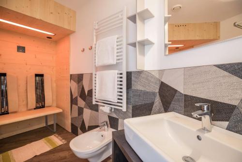 a bathroom with a sink and a toilet at Apartment Treï Residence Bun Ste in San Vigilio Di Marebbe