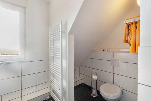 a white bathroom with a toilet and a window at Edos Private Zimmervermietung in Birstein
