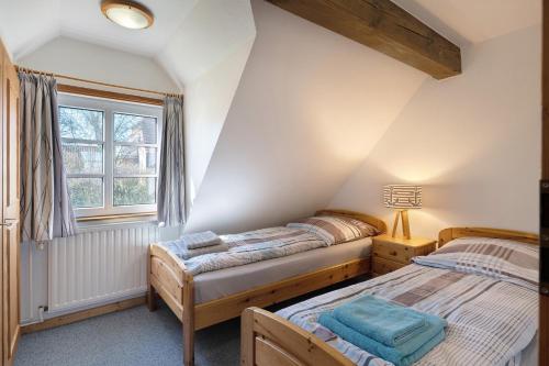two beds in a room with a window at Haus Möwe und Robbe in Dagebüll