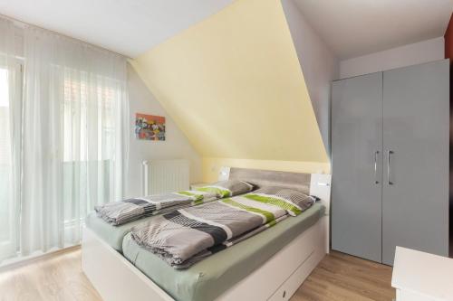 a bed in a room with a yellow wall at Edos Private Zimmervermietung in Birstein