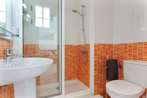 a bathroom with a shower and a toilet and a sink at La Casita Encantada in Corralejo
