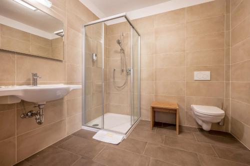 a bathroom with a shower and a sink and a toilet at Ferienwohnung Sonneck in Natz-Schabs
