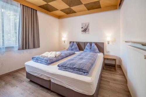 a bedroom with a bed with blue pillows at Ferienwohnung Sonneck in Natz-Schabs