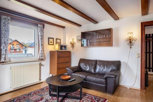 a living room with a leather couch and a table at Hirschenhäusle in Sankt Märgen