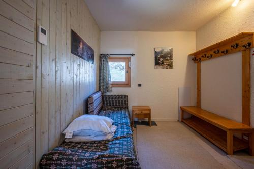 a small bedroom with a bed and a window at Les arolles in Valloire