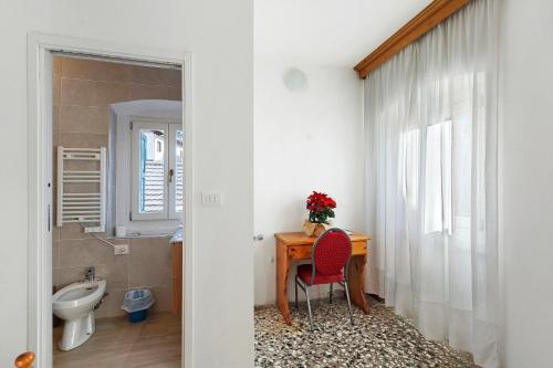un bagno con una scrivania, un lavandino e un water di Albergo Trieste - Lorenzago a Lorenzago