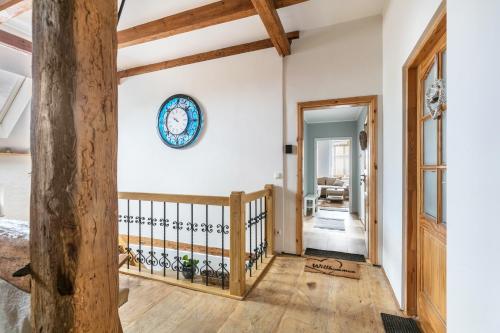 a staircase in a house with a clock on the wall at Ferienwohnung mit großem Garten in Lindow