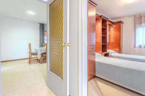 a bedroom with a bed and a door leading into a room at Casa Raymond con piscina in Maçanet de la Selva
