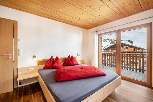a bedroom with a bed with red pillows on it at Seppnerhof Ferienwohnung Enzian in Moso
