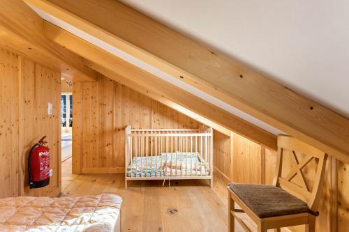 a room with a crib in a room with wooden walls at Ferienwohnung Bergkristall in Mittenwald