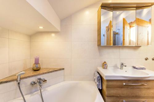 a bathroom with a tub and a sink and a mirror at Ferienwohnung Bergkristall in Mittenwald