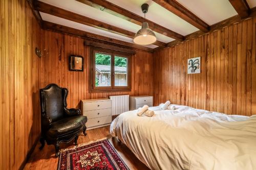 a bedroom with a bed and a leather chair at Chalet Chez Juju in Abondance