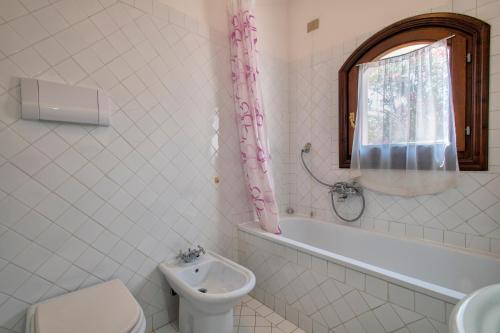 a bathroom with a toilet and a sink and a tub at Trilocale Fiordaliso in Stintino