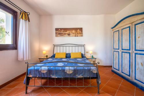 a bedroom with a blue bed with two yellow pillows at Trilocale Fiordaliso in Stintino