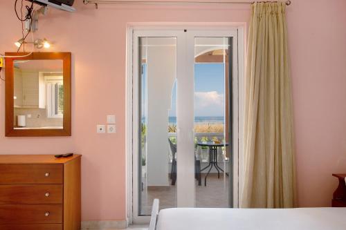 a bedroom with a sliding glass door with a view of the ocean at Apartment Vorrisi in Alykes