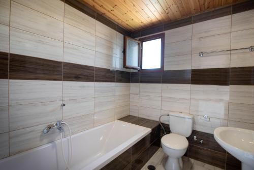a bathroom with a tub and a toilet and a sink at Mirage Arillas Studio Type C19 in Arillas