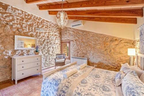 a bedroom with a bed and a stone wall at Casa Martin in Calvià