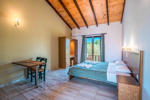 a bedroom with a bed and a desk and a table at Mirage Arillas Studio Type C19 in Arillas