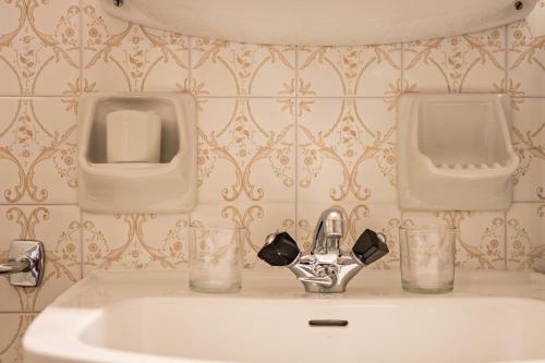 a bathroom with a sink and two urinals on the wall at Ferienwohnung 4 Vikoler in Vols am Schlern