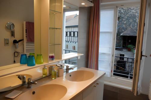 a bathroom with two sinks and a large mirror at Cour Du Weinhof à Colmar in Colmar