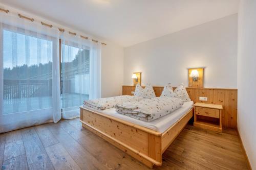 a bedroom with a bed and a large window at Maurerhof Abendrot in Maranza