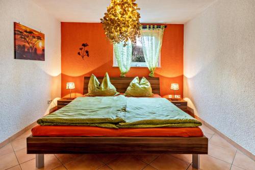 a bedroom with a bed in an orange wall at Ferienwohnung Im Holzhaus in Donaueschingen