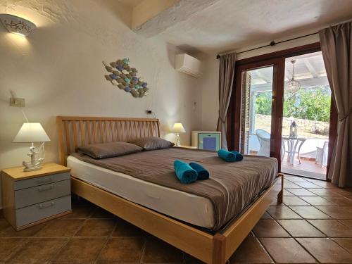 a bedroom with a bed with blue pillows on it at Villa Luna Rossa con piscina in San Teodoro