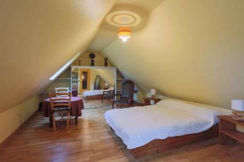 a bedroom with a bed and a table and chairs at Gîte Ty Coz in Lanvellec