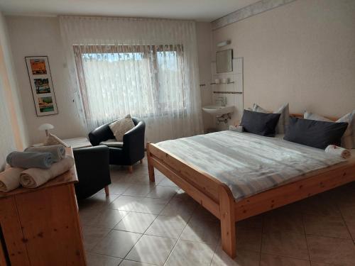 a bedroom with a large bed and chairs in it at Ferienwohnung-Pension Osterwiese in Weilburg